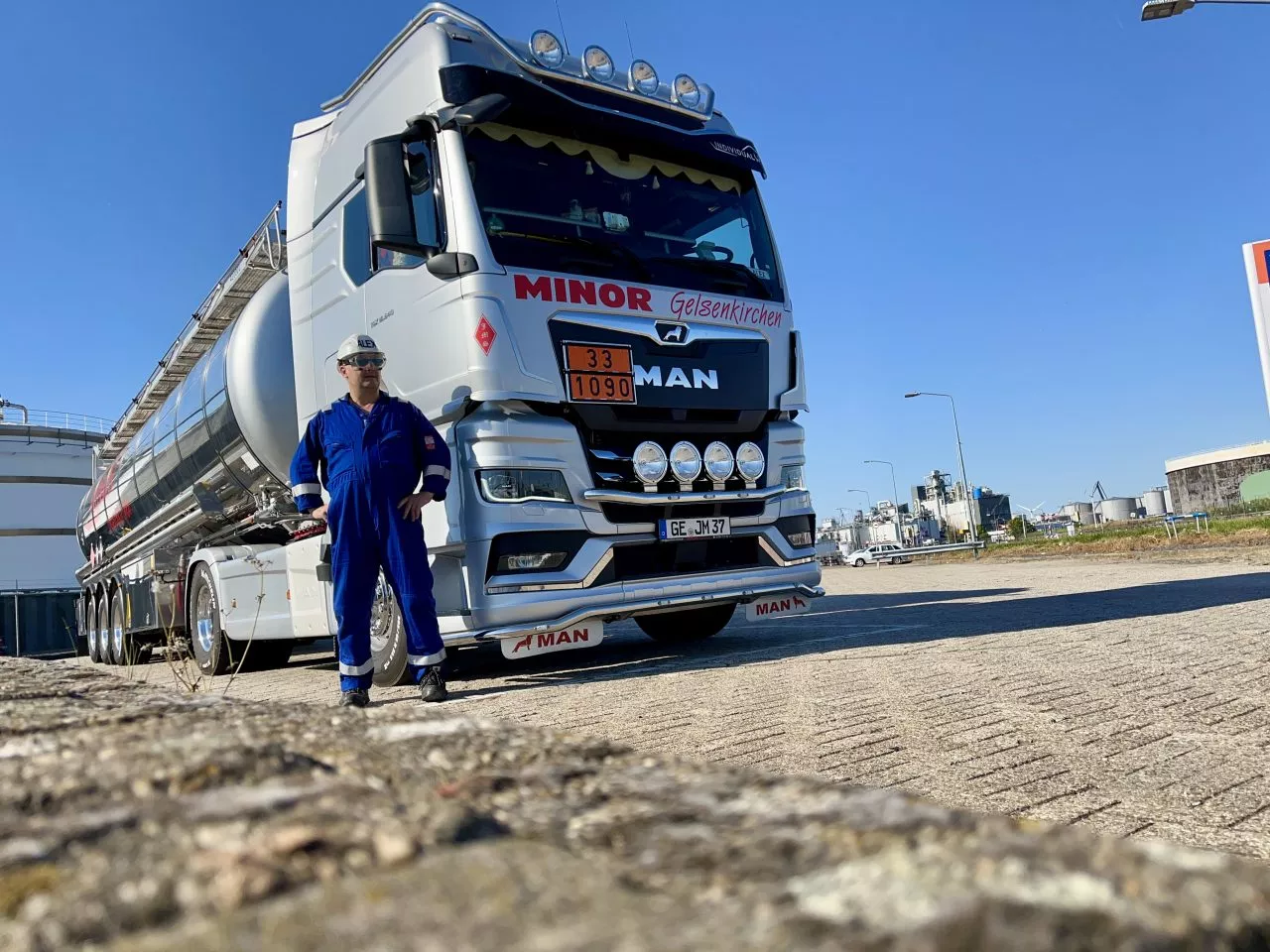 Fahrer der Spedition Minor vor seinem Edelstahl-Tankzug auf einem Industriegelände